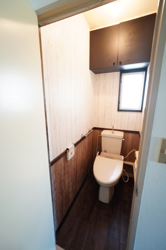 天付け収納のあるトイレです。こだわりのアクセントクロスがポイントとなっております。