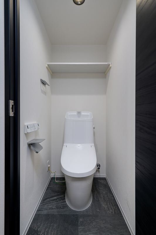 上部収納付きの清潔感あるトイレスペース。日用品の保管にも便利です。